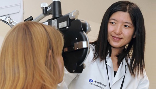 ophthalmologist positions machine to begin eye exam