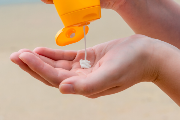 Close-up photo of a bottle of sunscreen over an open hand, palm-up