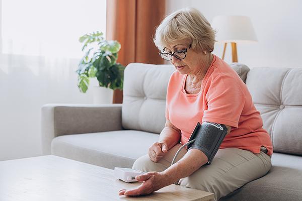 Mature patient taking her blood pressure at home