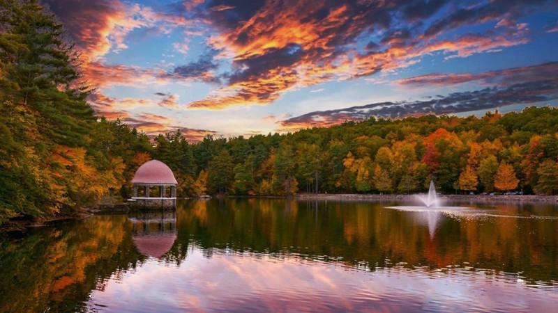 Fall is upon us and represented with the beautiful fall colors of the trees at the edge of a lake.