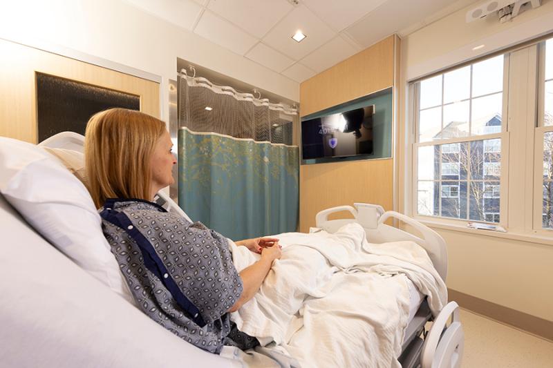 A patient in the North Pavilion looks through the window from her bed.