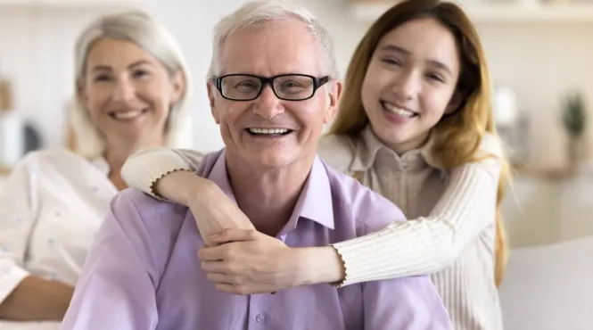 Grandfather with afib being hugged by granddaughter while grandma watches