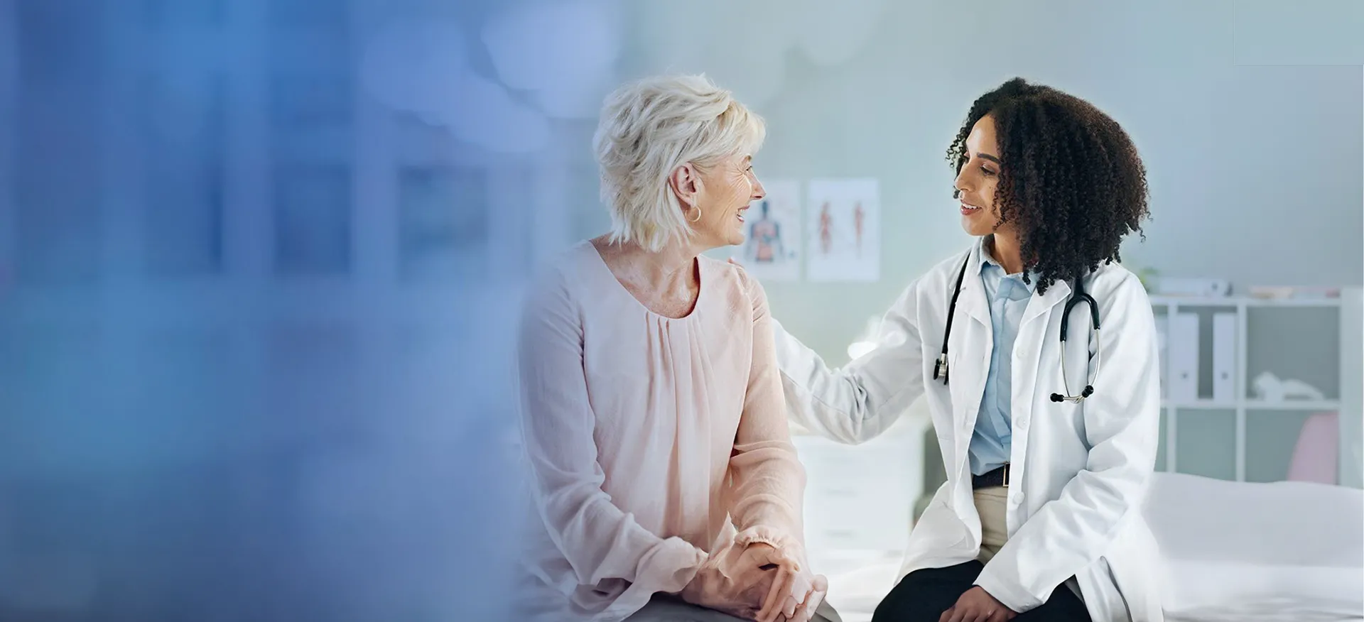 A patient and doctor are having a conversation while the doctor touches the patient's shoulder, highlighting a warm welcome for patients.