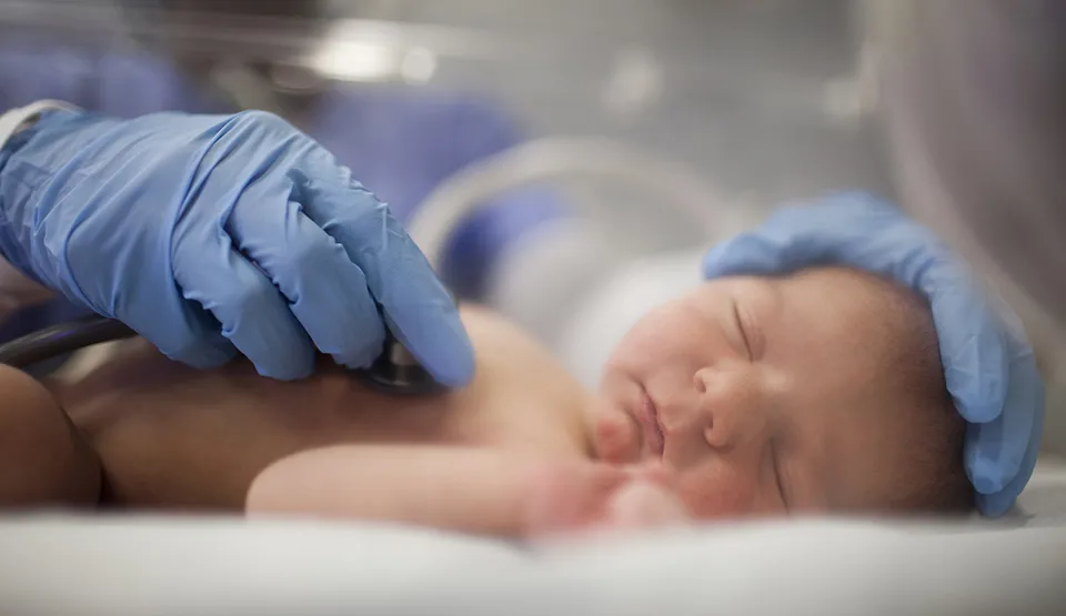 A newborn is being examined in the NICU.