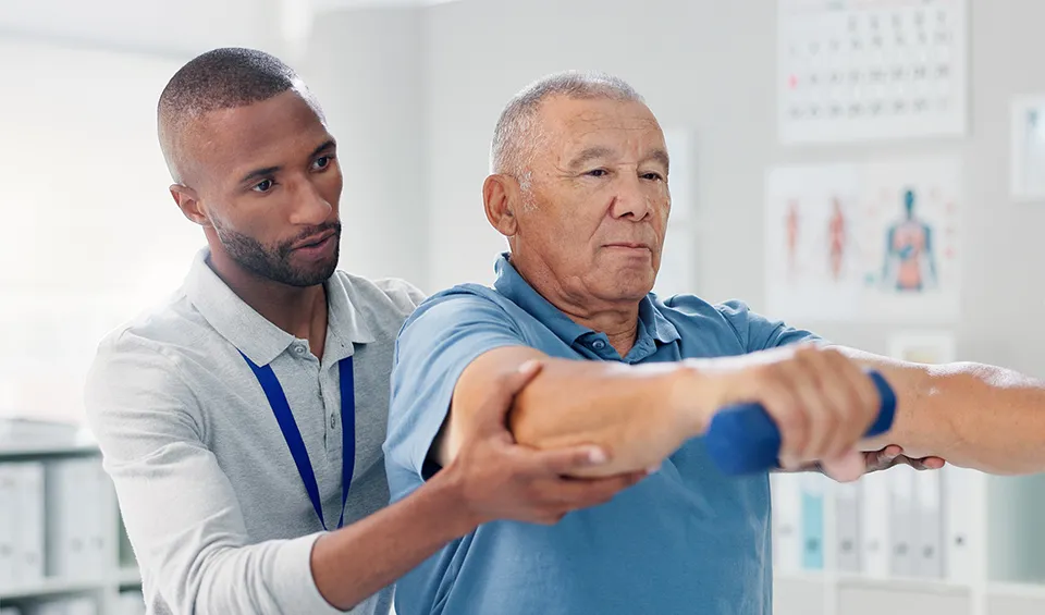 A physical therapists assists a patient with the correct way to do a weight exercise.