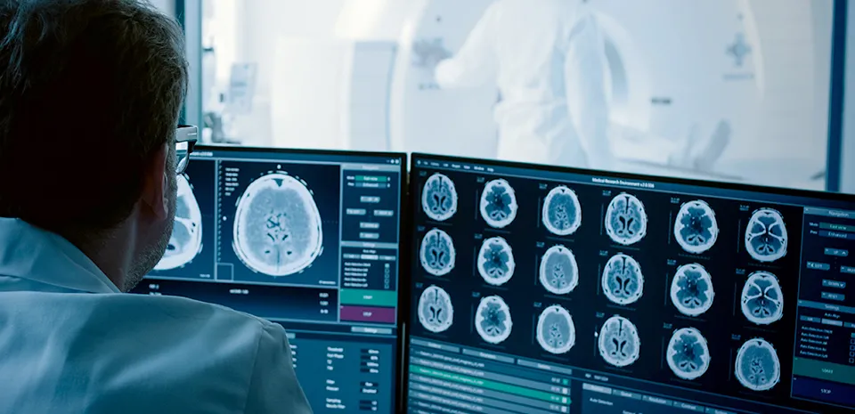 Image of physician looking at brain images on the screen