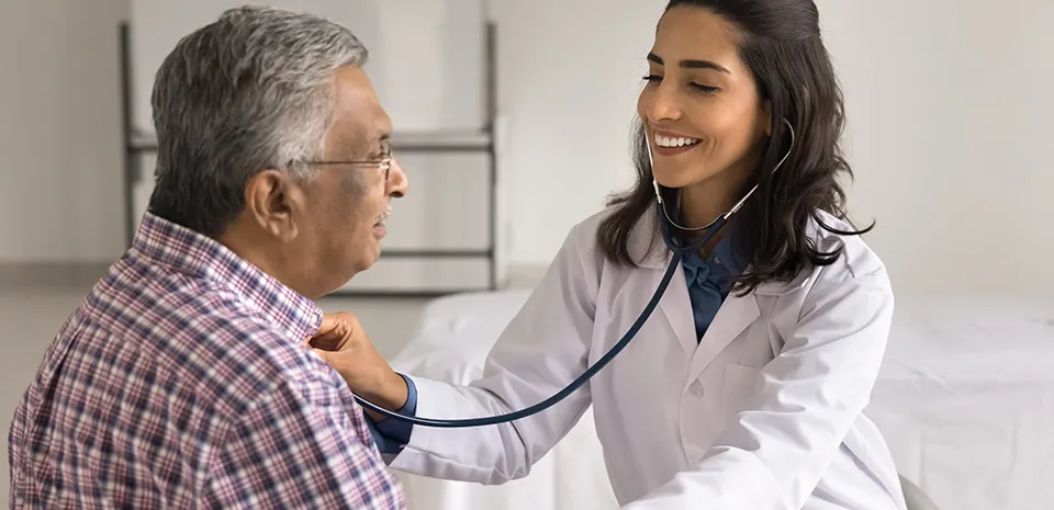 Image of woman doctor with a stethoscope to a patient