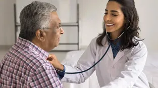 A doctor uses a stethoscope to listen to her patient's heart.