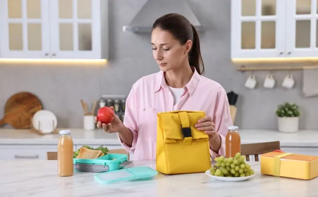 Woman at a kitchen counter prepping her balanced lunch with healthy foods 